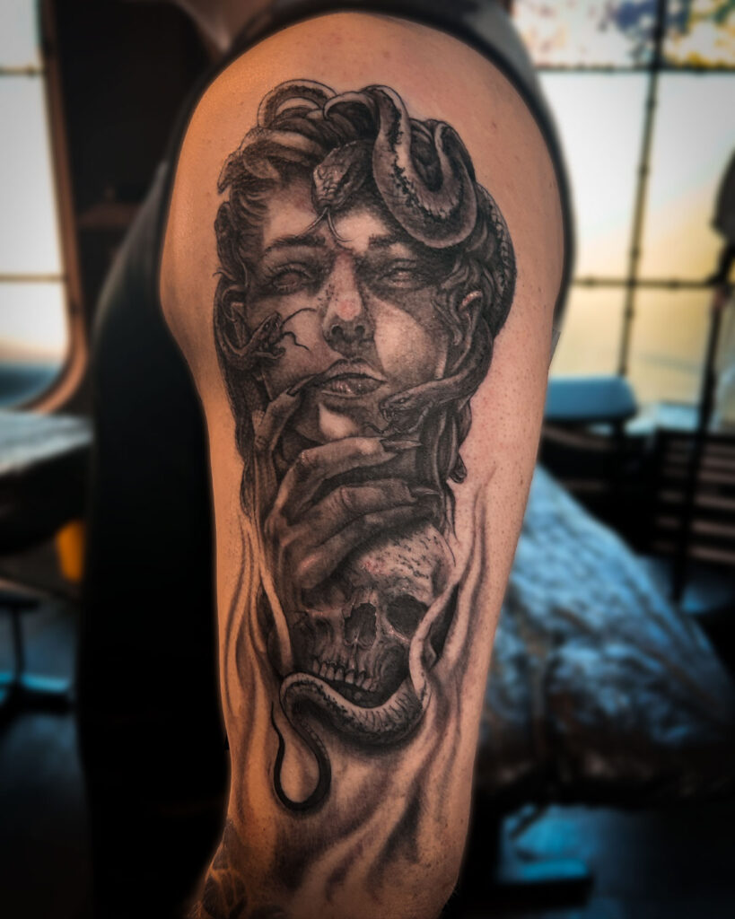 Tatuaje de una medusa o gorgona, con una calavera, estilo realismo, en el brazo, tatuado por kaorukel