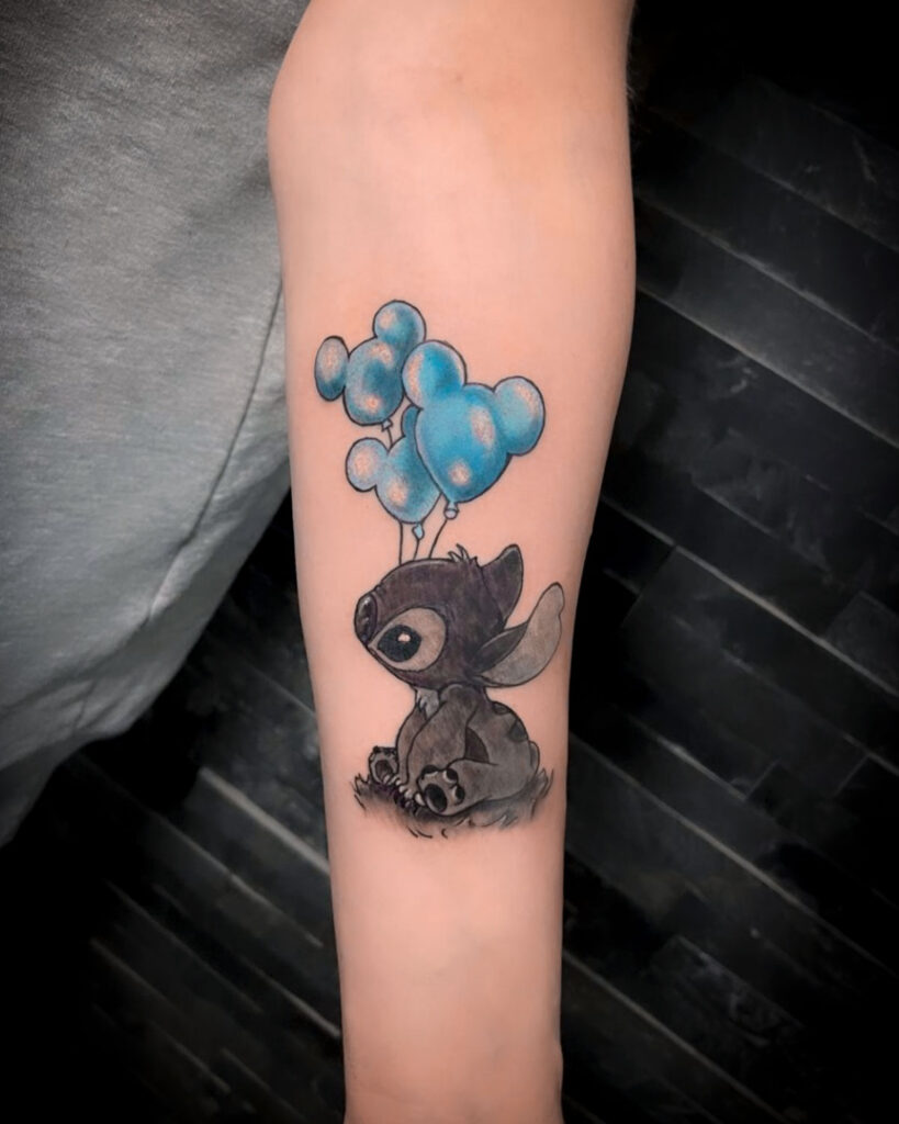 Tatuaje de Stitch con globos azules en forma de mikey mouse, tatuado por kaorukel