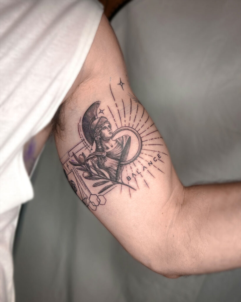 Tatuaje de Atenea con una rama de olivo, la palabra balance, estilo georealismo, tatuado por kaorukel
