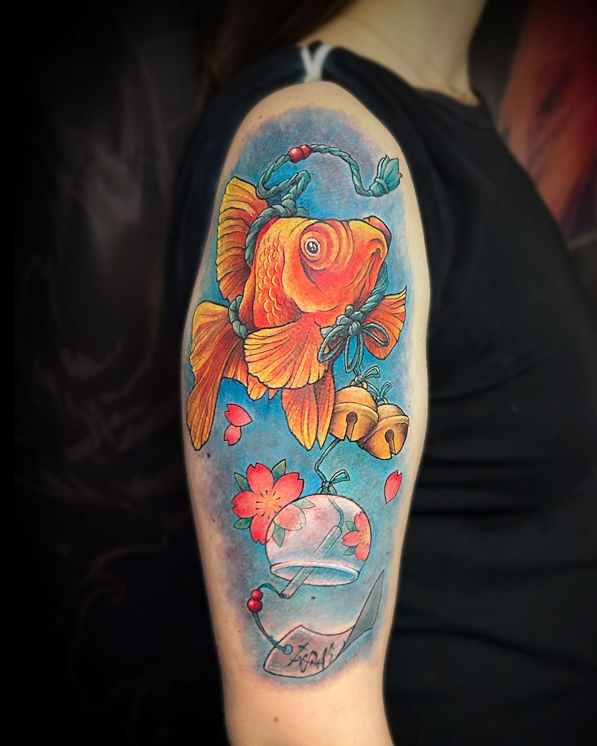 Tatuaje a todo colore de un golden fish, pez, con cascabeles y un tuurin o campana de viento japonesa, estilo japonés, tatuado por kaorukel