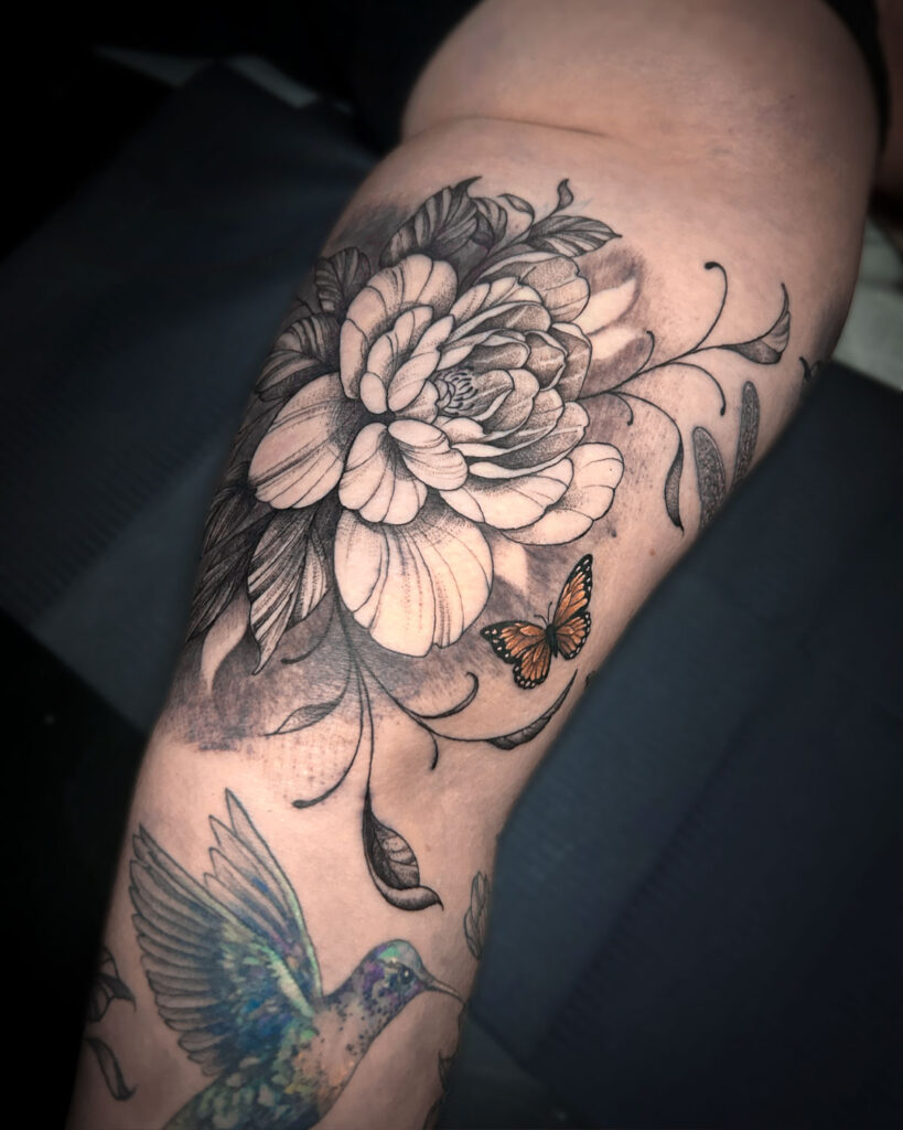 Tatuaje de una peonía en el interior del biceps, con una mariposa, estilo japonés, tatuado por kaorukel