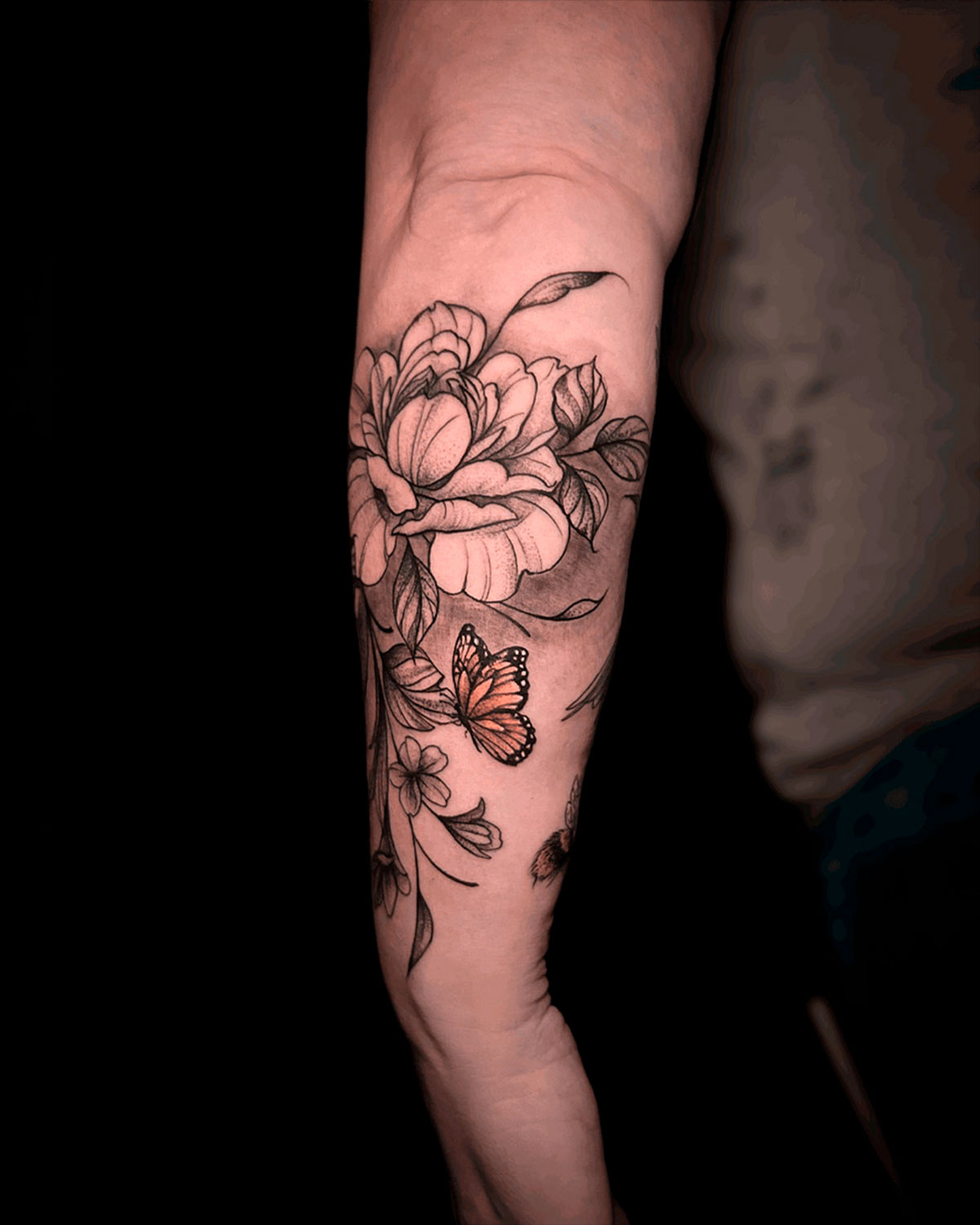 Tatuaje de una peonía, con hojas y una mariposa a color, estilo japonés, en el antebrazo, tatuado por kaorukel