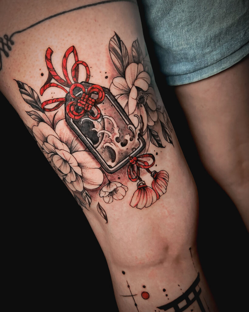 Tatuaje de un omamori o amuleto japonés, con peonías, estilo japonés, color negro y rojo, tatuado por kaorukel