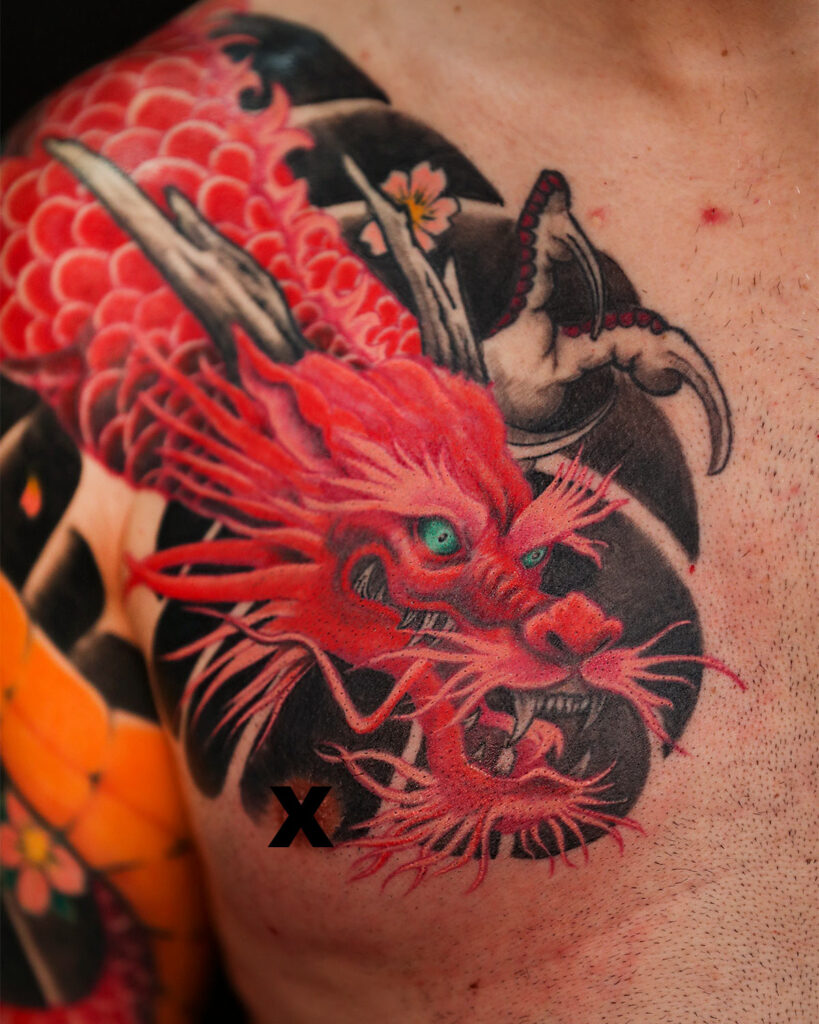 Tatuaje de un dragón rojo, centrado en la cabeza, en el pecho, estilo japonés, tatuado por kaorukel