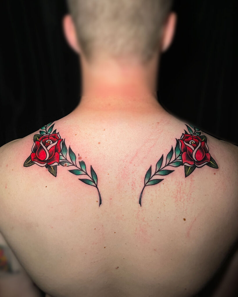 Tatuaje simétrico en la espalda de unas rosas y unas hojas, a color, estilo tradi otradicional, tatuado por kaorukel