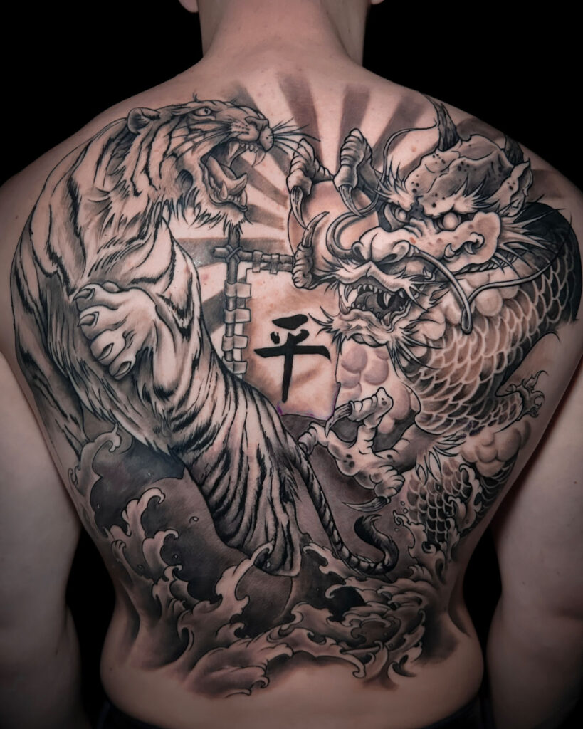 Tatuaje en espalda completa, de un rigre y un dragón enfrentados, estilo japonés, en blanco y negro, tatuado por kaorukel