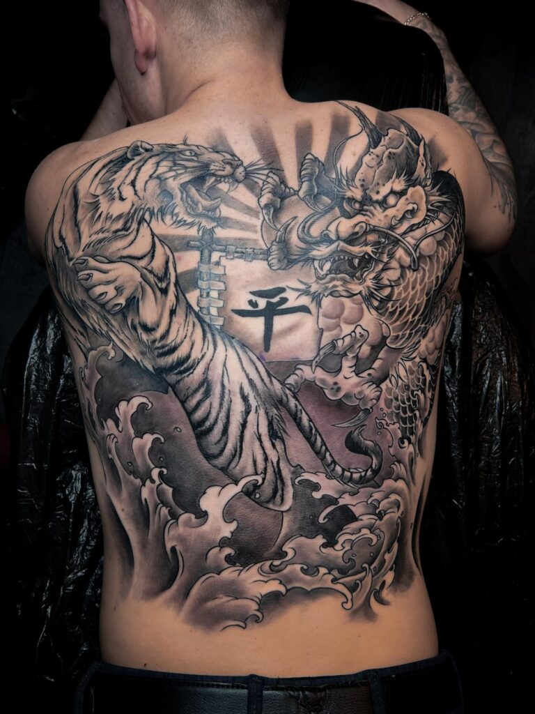 Tatuaje de un tigre y un dragón en blanco y negro en una espalda completa realizado por Kaorukel Tattoo