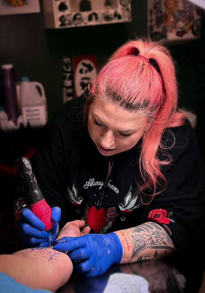 Kaorukel tatuando un antebrazo en una cabina de un estudio de tatuajes