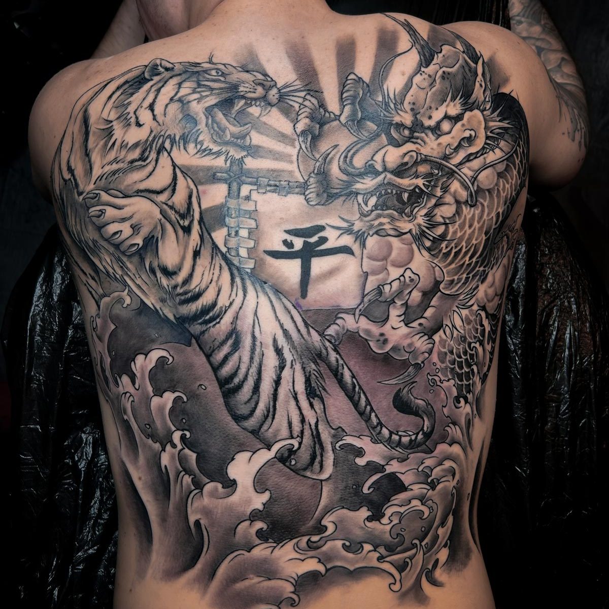 Tatuaje de un tigre y un dragón en blanco y negro en una espalda completa realizado por Kaorukel Tattoo